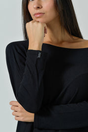 Dettaglio del bordo scollo e della manica lunga della maglia nera